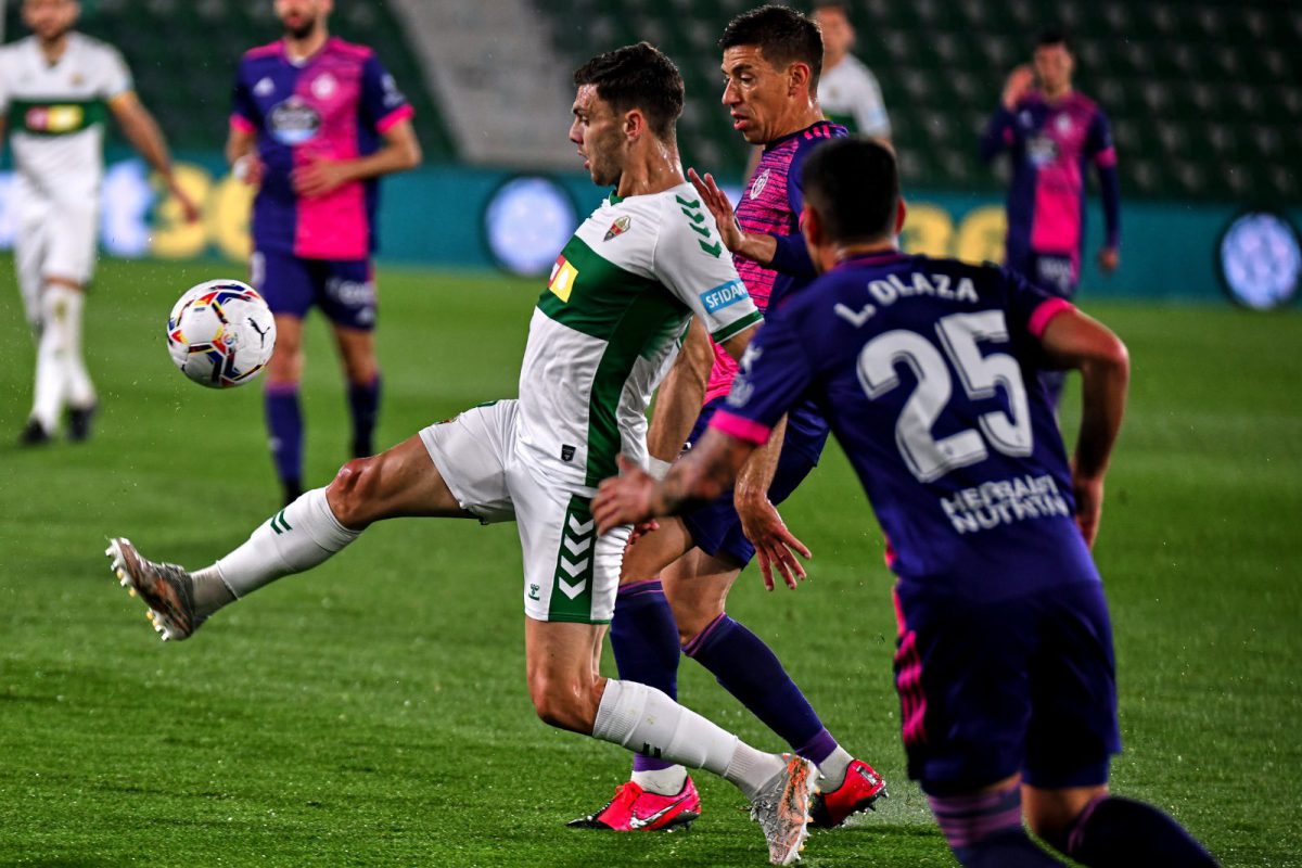 Lucas Olaza intenta robar el balón al delantero del Elche CF con la ayuda de un compañero.