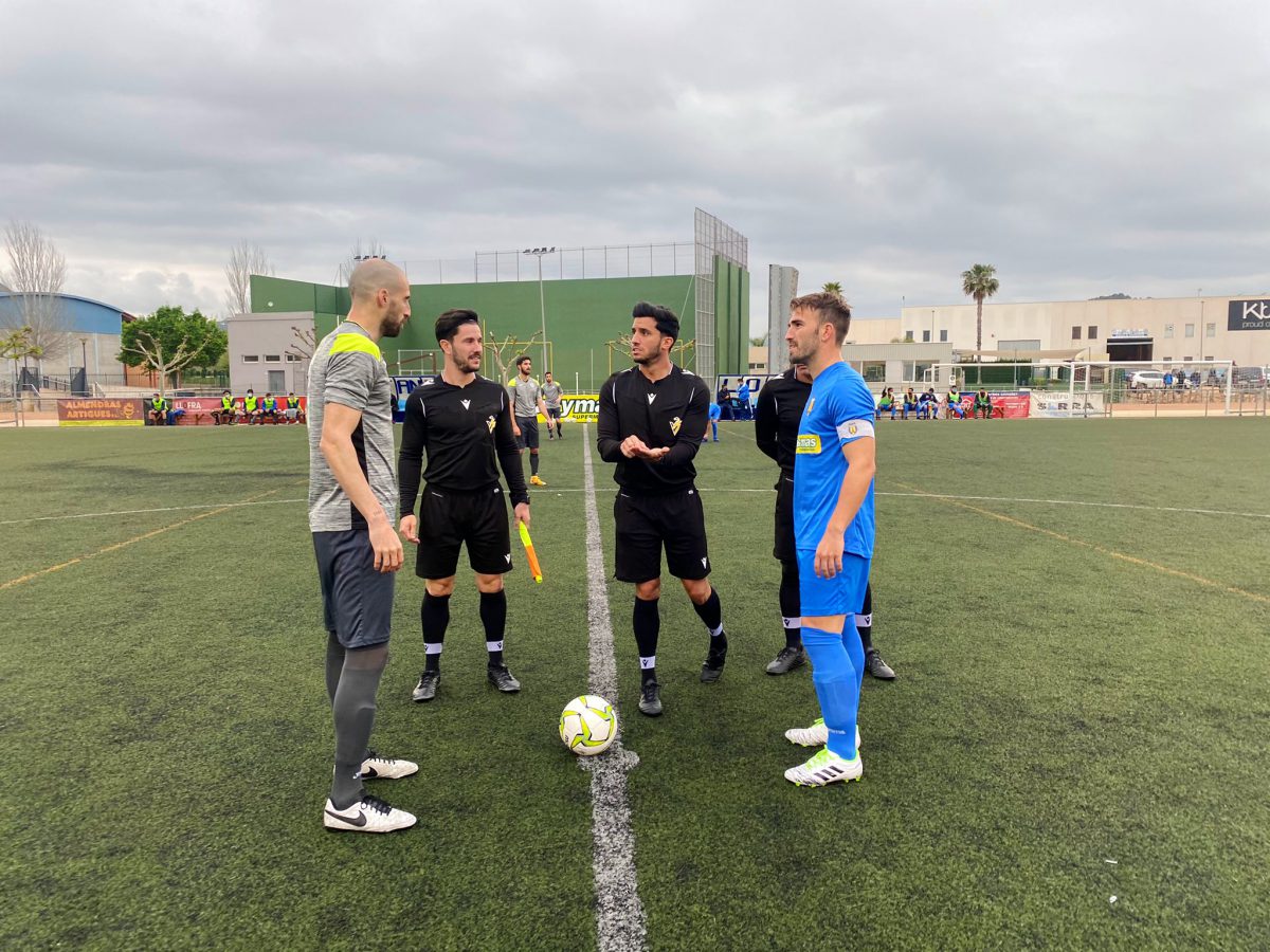 El árbitro principal realiza el sorteo de campo con los dos capitanes.