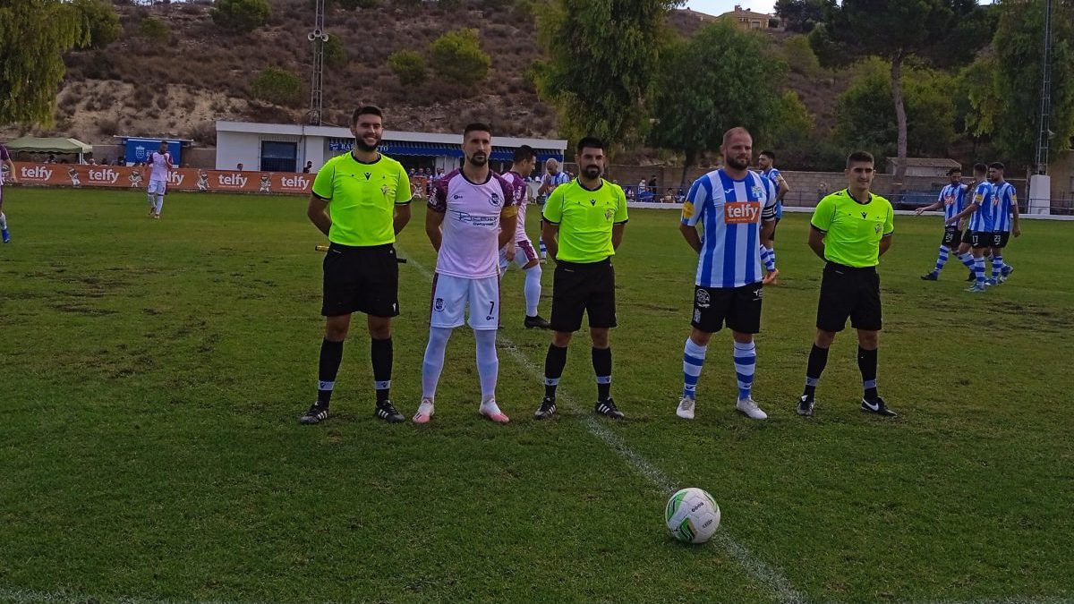 Los dos capitanes junto al trío arbitral