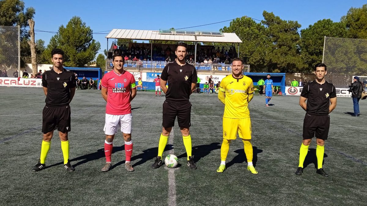 Los capitanes posan junto al trío arbitral.