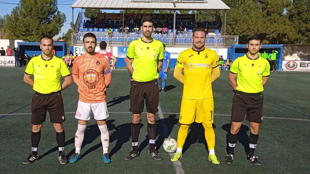 Los capitanes posan junto al trío arbitral.