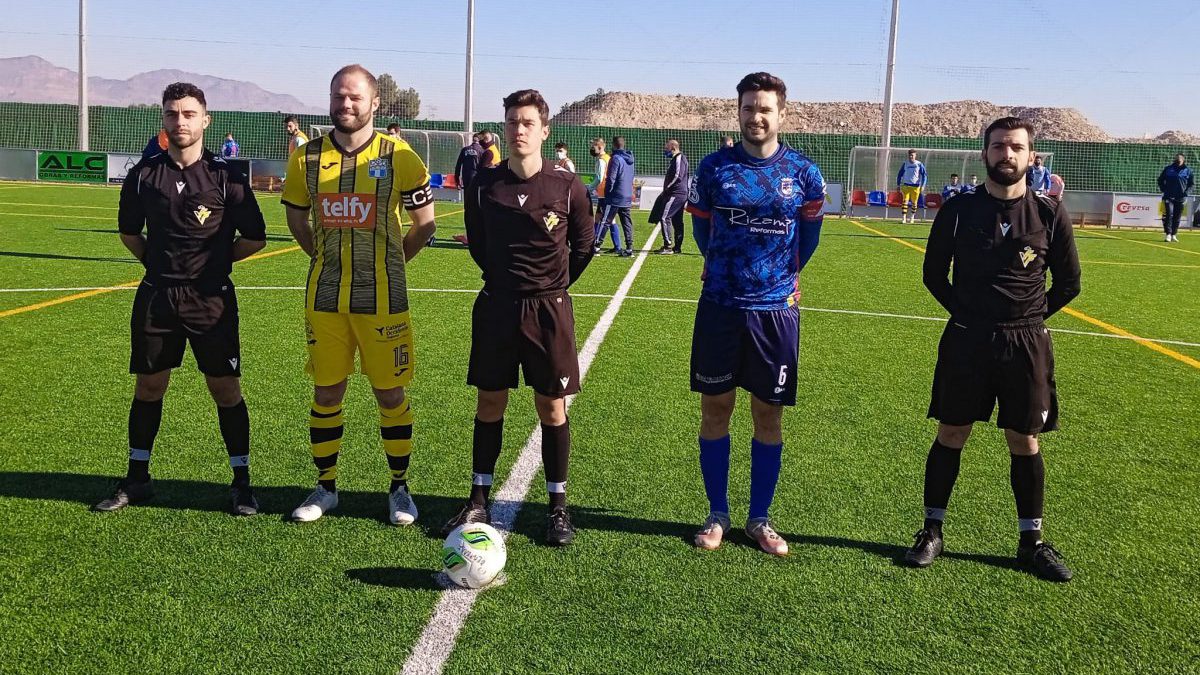 Capitanes y trío arbitral posan antes de empezar.