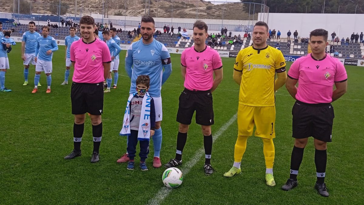 Los capitanes posan junto al trío arbitral.