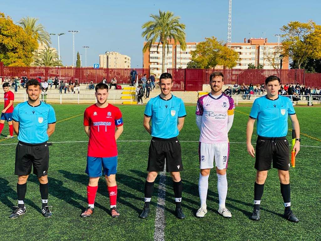 El trío arbitral posa con los capitanes.