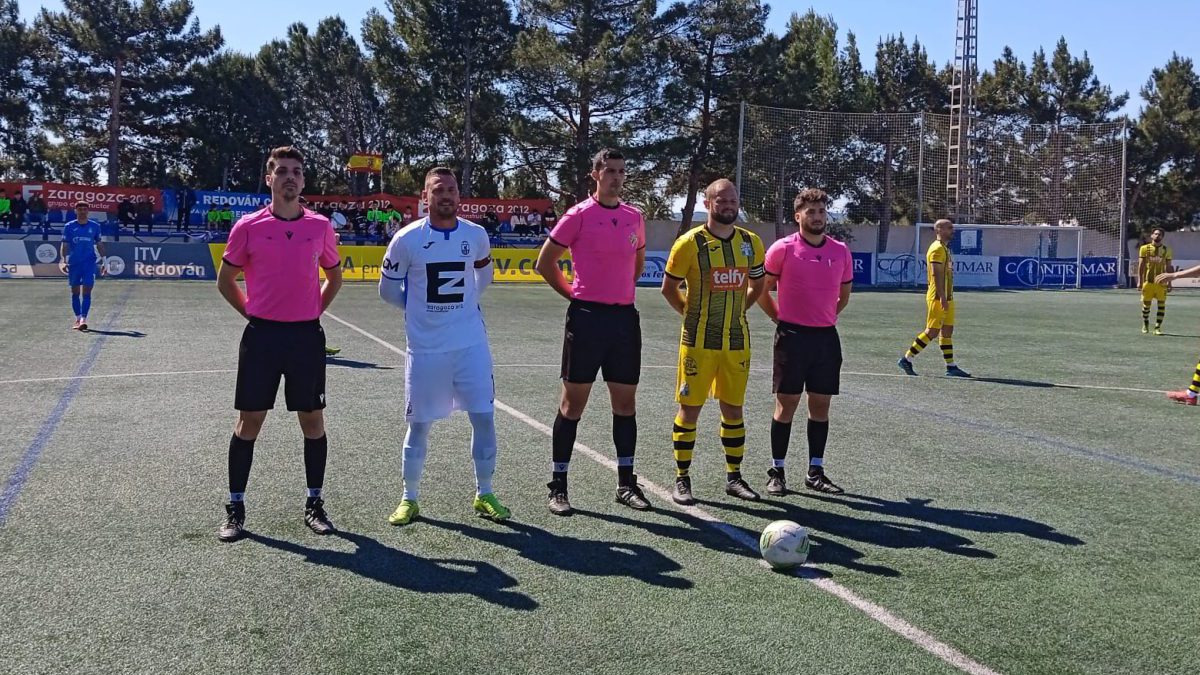 El trío arbitral junto a los capitanes