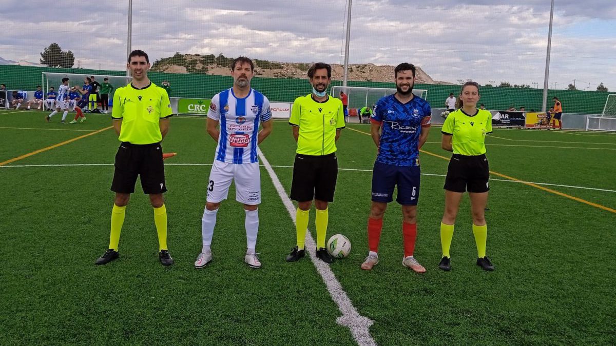 El trío arbitral junto a los capitanes.