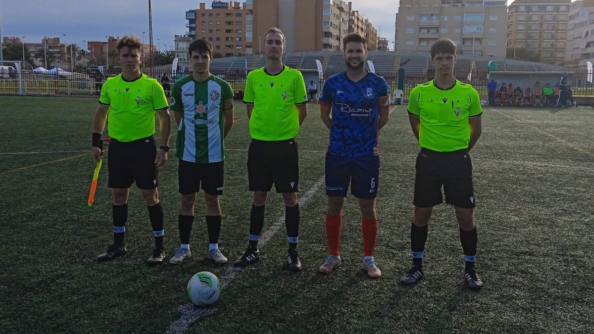 Los capitanes posan junto al trío arbitral.