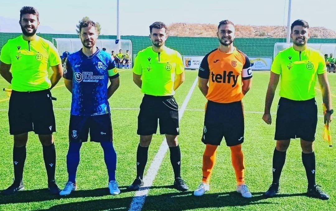 El trío arbitral junto a los capitanes