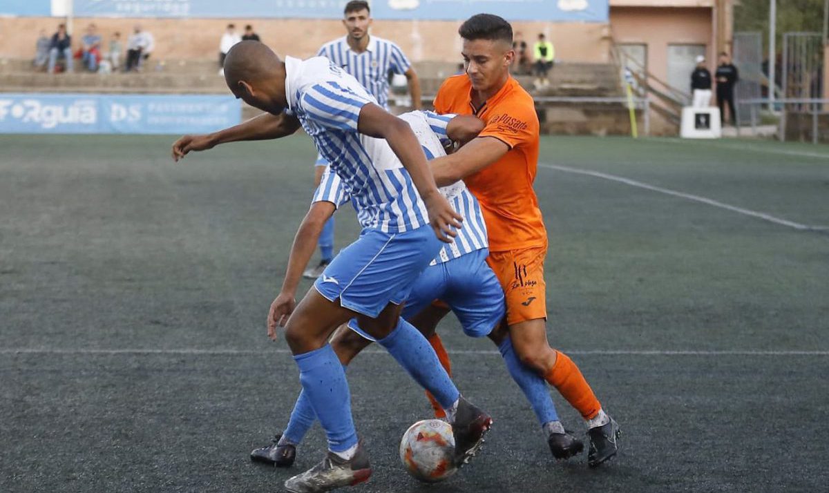 Mario Tomé forcejea con dos jugadores