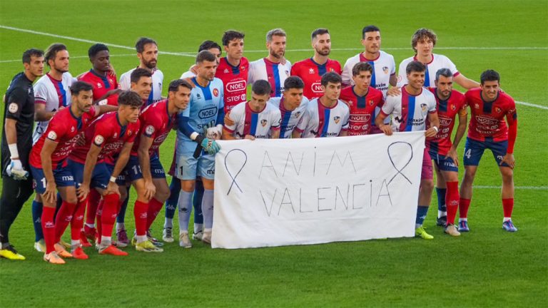 Los jugadores del Olot y Alzira con la pancarta de apoyo a los afectados por la DANA. Foto: UE Olot.