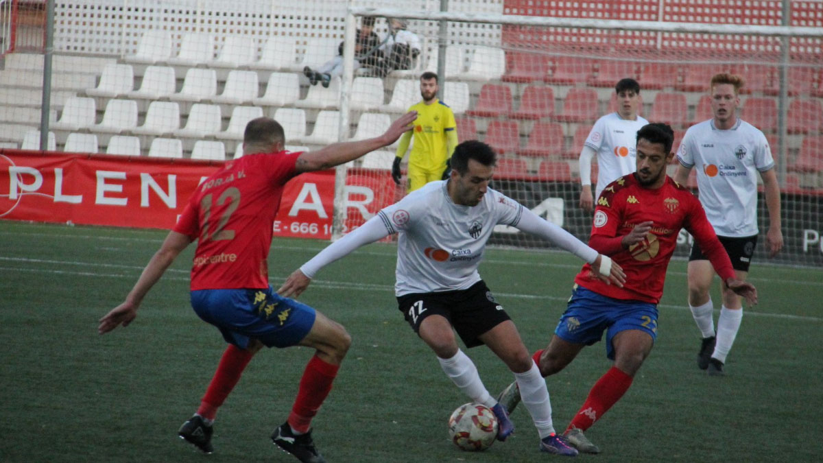 Casti ante dos jugadores del Saguntino. Foto: Ontinyent 1931. 